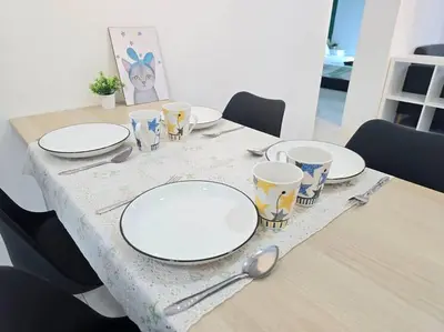 a table with plates and utensils on top of it at Stay at Anderson Condo 161 Ipoh Town FREEWIFITVBOX in Ipoh