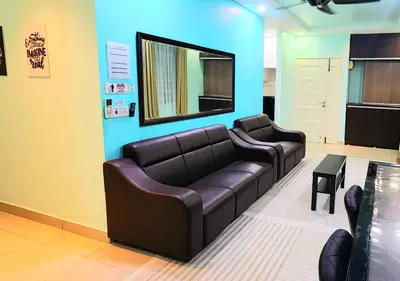 a waiting room with a couch and a mirror at Homestay Pulau Pinang Urban Sky Guesthouse in Bayan Lepas
