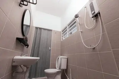 a bathroom with a toilet and a sink and a mirror at Taiping Homestay 5R3B, 9mins - Zoo & Lake Garden Taiping in Taiping