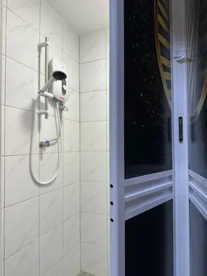 a shower with a shower head in a bathroom at Milan Backpacker Hostel in George Town