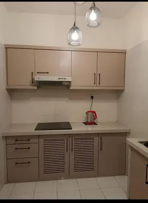 a kitchen with white cabinets and a mixer on a counter at Seri Sayang 2 Bedrooms Seaview Resort in Batu Ferringhi