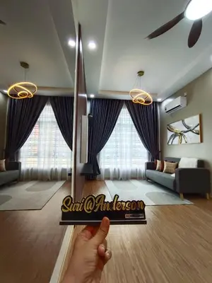a living room with a person holding up a sign at Suri Homestay Anderson Ipoh in Ipoh