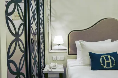 a hotel room with a bed with a blue pillow at The Host Hotel in Ipoh