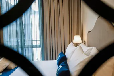 a bedroom with a bed with pillows and a window at The Host Hotel in Ipoh