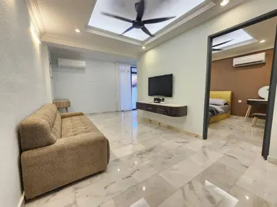 a living room with a couch and a flat screen tv at Sunway Homestay 8pax 2Bath in Perai