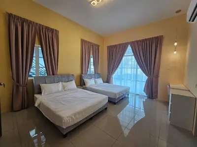 two beds in a large room with windows at jia Residence 21 pax Karaoke & Snooker in Ipoh