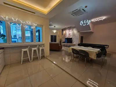 a dining room with a table and some stools at jia Residence 21 pax Karaoke & Snooker in Ipoh