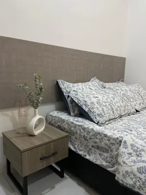 a bedroom with a bed with a vase on a night stand at The Imans Place in Kepala Batas