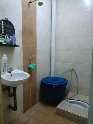 a bathroom with a blue toilet and a sink at Seri Raban Homestay in Kampong Kuala Chegar