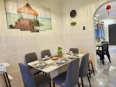 a dining room with a white table and chairs at IPOH Rainbow Blissful Villa, Persiaran Halaman Ampang Ipoh in Ipoh