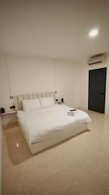a large white bed in a white room at 23 Inn Kingbed Room with Balcony in Bukit Mertajam