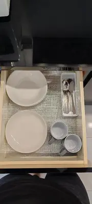 a table with white plates and utensils on it at 23 Inn Kingbed Room with Balcony in Bukit Mertajam