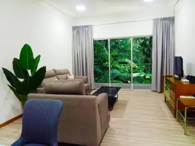a living room with a couch and a large window at Quintet Cottage in Cameron Highlands