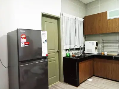 a kitchen with a stainless steel refrigerator in it at Quintet Cottage in Cameron Highlands