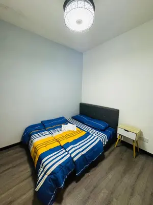 a bedroom with a bed with a blue and yellow blanket at AYAAN Comfy Homestay with FREE WiFi in Tanah Rata