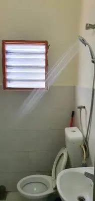 a bathroom with a toilet and a sink and a window at Taman Medan Seri Sentosa, Ayer Tawar in Ayer Tawar