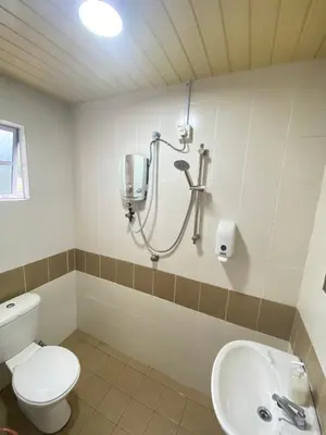 a bathroom with a shower and a toilet and a sink at Qaseh Homestay Cameron Highlands 5 in Brinchang