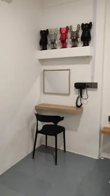 a room with a table and a chair and a shelf at 23 Inn Queenbed Standard Room in Bukit Mertajam