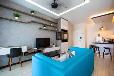 a living room with a blue couch and a kitchen at Mansion One l 5pax Studio l Seaview & Cityview l Georgetown l by PerfectSweetHome in George Town