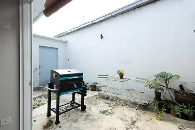 a grill sitting on a stand in a patio at InWood - Pet allow Ipoh homestay & BBQ in Ipoh