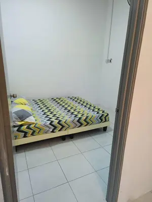 a bed in a room next to a mirror at Rumah SK in Batu Kurau