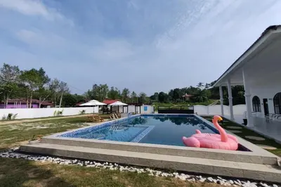 a swimming pool with a pink flamingo in a yard at Grand Aeden Villa in Kuala Kangsar