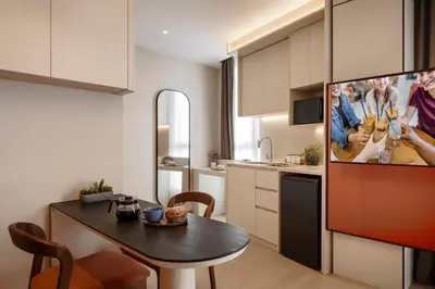 a kitchen with a table and a tv in a room at Citadines Tanjung Tokong Penang in George Town