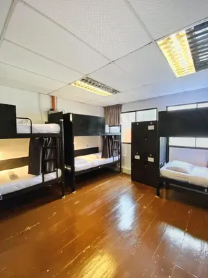 a room with three bunk beds and a wooden floor at Pine Armenian in George Town