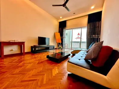a living room with a couch and a television at 2 bedroom Suite with Sea View At Straits Quay in Tanjong Tokong