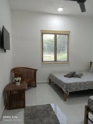 a living room with two beds and a window at Bilik Naqiah in Gerik