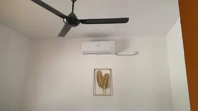 a ceiling fan and a picture on a wall at Bilik Naqiah in Gerik