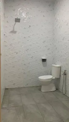 a white bathroom with a toilet in a room at Bilik Naqiah in Gerik