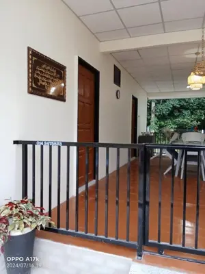 a balcony with a black railing and a table at Bilik Naqiah in Gerik