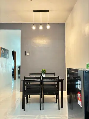 a dining room table with black chairs and lights at KH Homestay 2 Seri Manjung in Seri Manjung