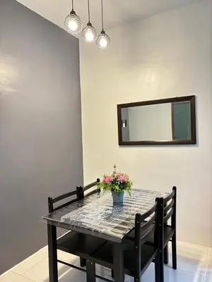 a dining room table with a vase of flowers on it at KH Homestay 2 Seri Manjung in Seri Manjung