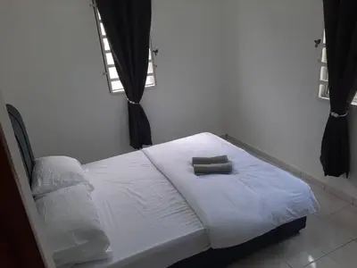 a white bed in a room with a window at Fatimah HomeStay Kulim Hi Tech in Kulim