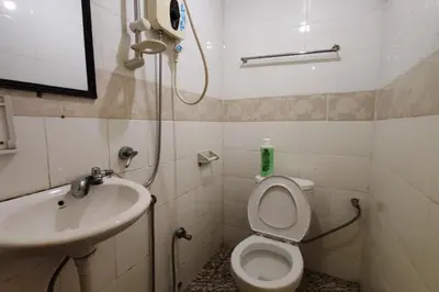 a small bathroom with a toilet and a sink at D'BJ Motel in Bayan Lepas