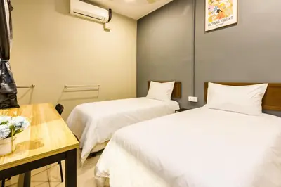 a room with two beds and a table at Urban 10pax Terrace Gem near Sunway Carnival in Perai