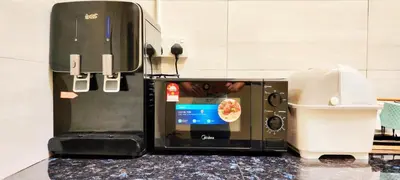 a microwave sitting on top of a kitchen counter at Urban 10pax Terrace Gem near Sunway Carnival in Perai