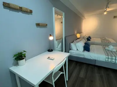 a room with a bed and a table and a mirror at NEW - Panorama Komtar SeaView Meritime Suites in Jelutong