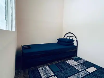 a bed in a room with a blue pillow on it at Inap Desa R'Sawit Pintu B in Sekincan