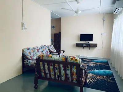 a living room with a couch and a tv at Inap Desa R'Sawit Pintu B in Sekincan