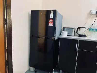 a black refrigerator in a kitchen next to a counter at Inap Desa R'Sawit Pintu B in Sekincan