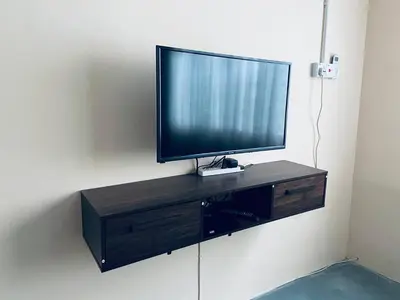 a flat screen tv sitting on top of a cabinet at Inap Desa R'Sawit - A dan B in Sekincan