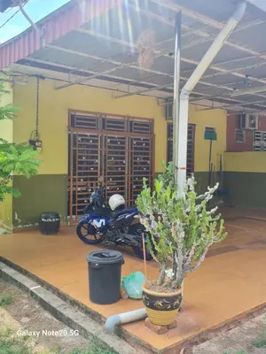 a motorcycle parked in a garage with a plant at de'berah homestay penaga in Penaga