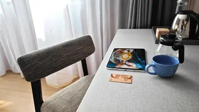 a table with a chair and a cup on it at Citadines Connect Cecil Georgetown Penang in George Town