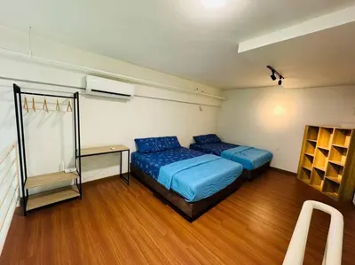 a bedroom with two beds and a desk in it at The CEO Suits in Bayan Lepas