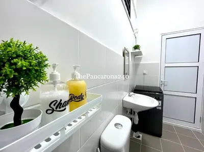 a white bathroom with a toilet and a sink at The Pancarona240 in Seri Iskandar