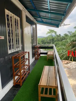 a porch with benches and grass on a house at Farhani Cabin Stay in Kampong Batu Lima