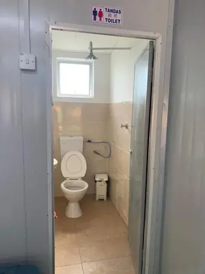 a small bathroom with a toilet and a window at Farhani Cabin Stay in Kampong Batu Lima
